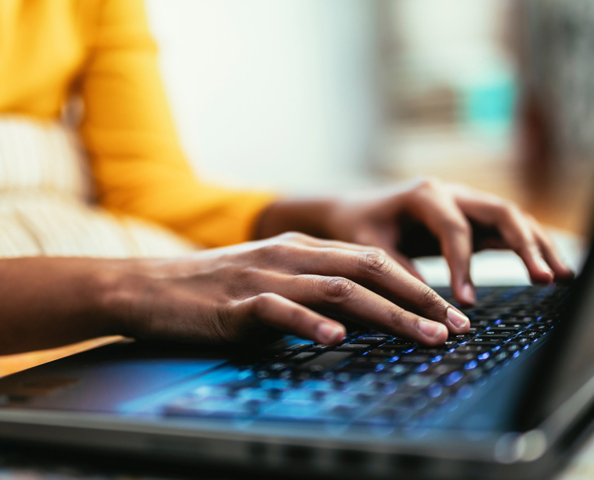 Close up hands typing using laptop computer