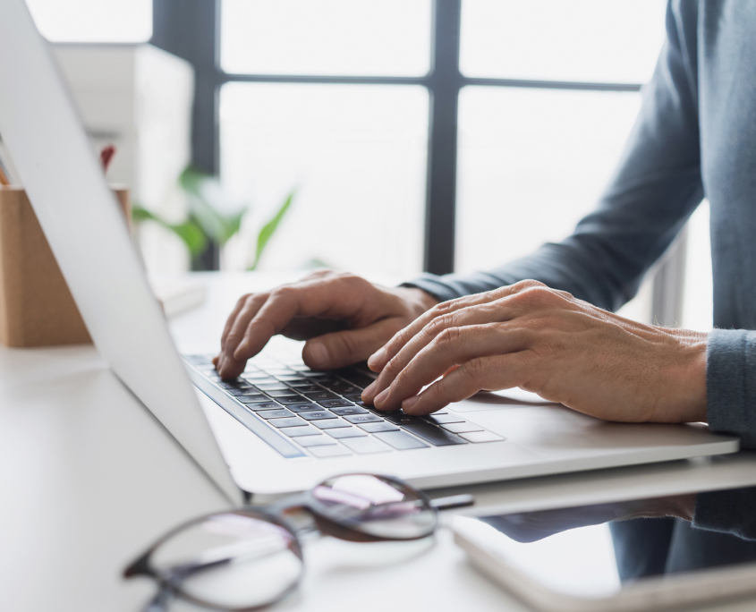 Side view of a man typing on laptop keyboard