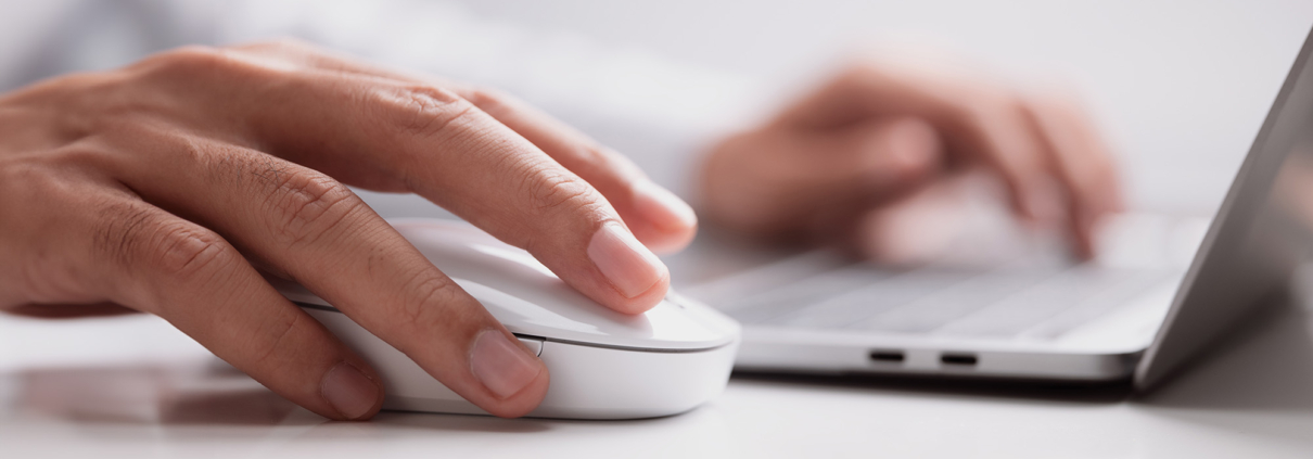 Side view of a man typing on laptop keyboard and moving mouse